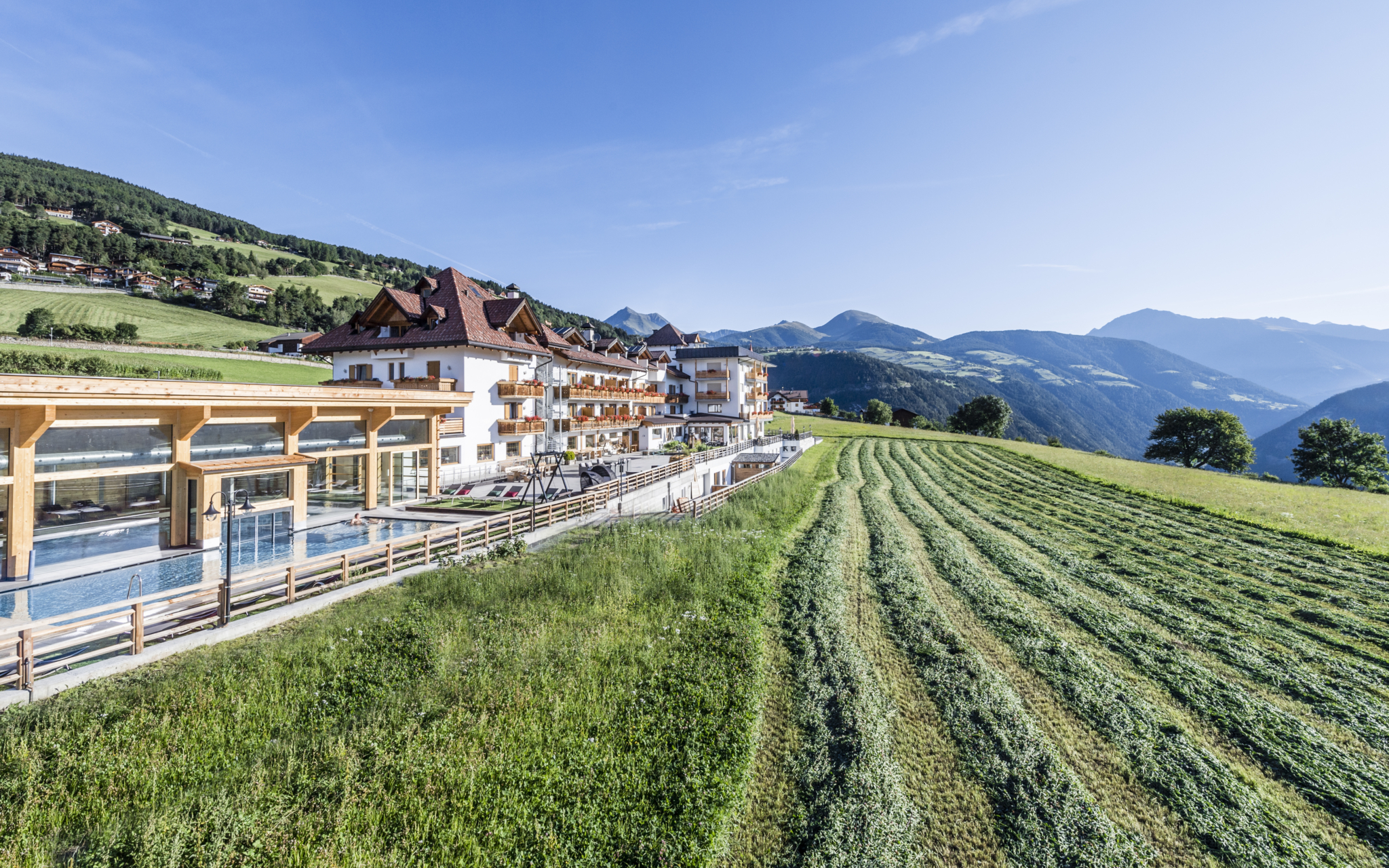Hotel Rogen mit weitläufigen Feldern und Blick auf die Südtiroler Berge