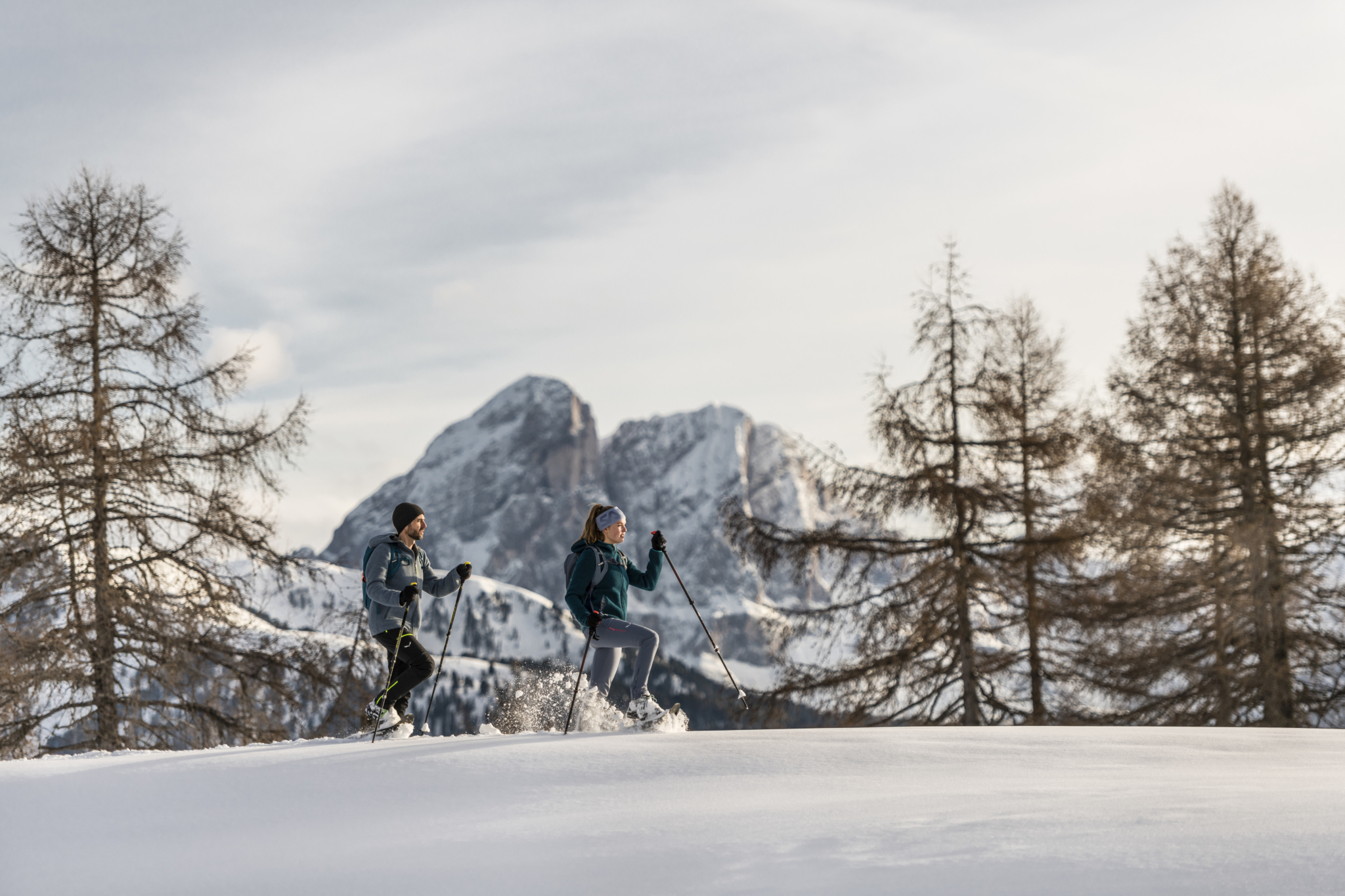 Winterwanderer unterwegs durch tiefen Schnee vor markanten Dolomitengipfeln