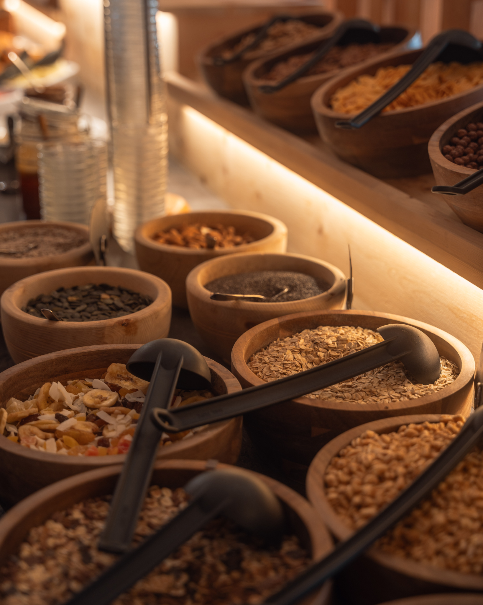 Schalen mit Nüssen, Trockenfrüchten, Müsli und weiteren Zutaten am Frühstücksbuffet