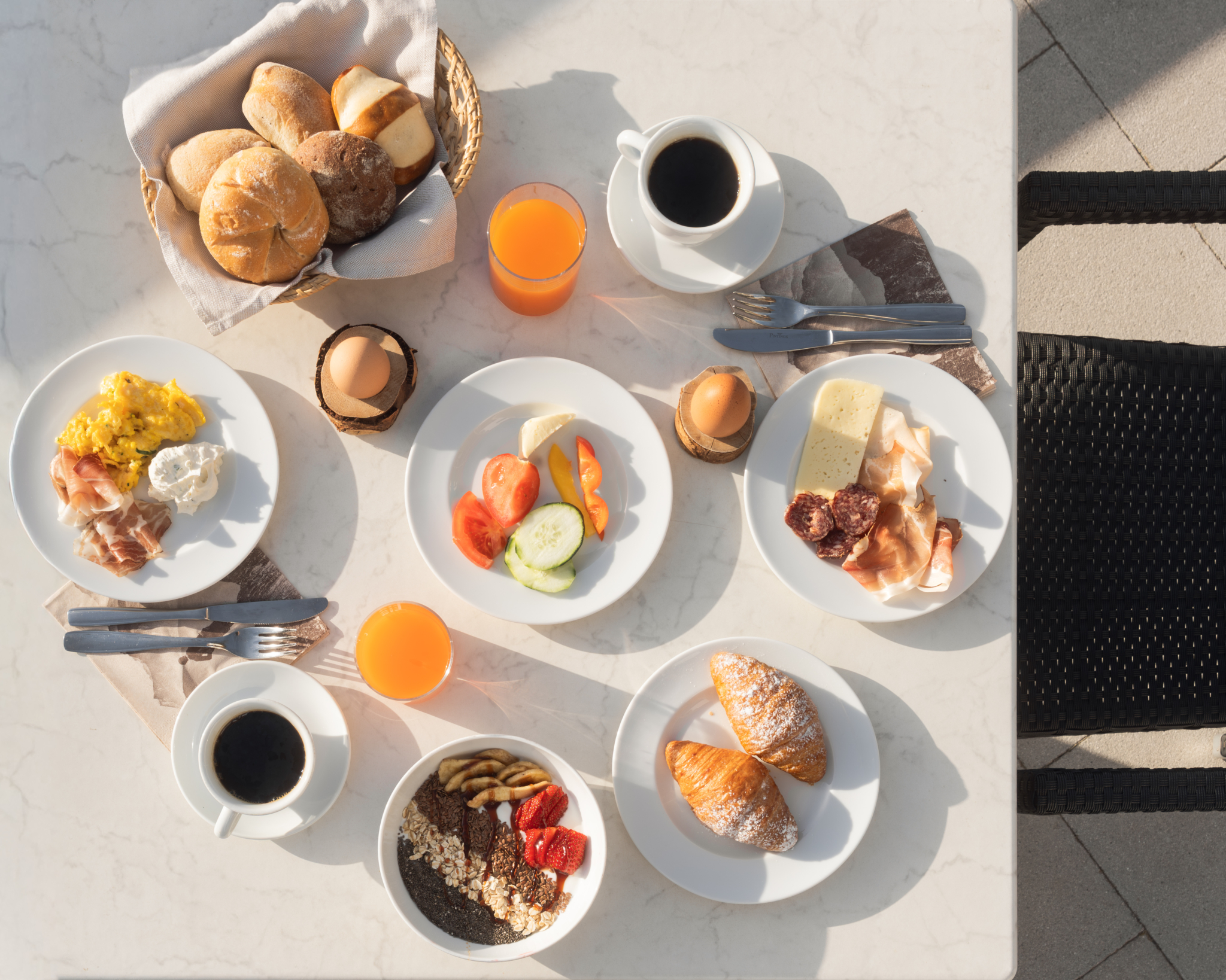 Frühstückstisch mit Kaffee, Säften, Brot, Obst und verschiedenen Speisen von oben